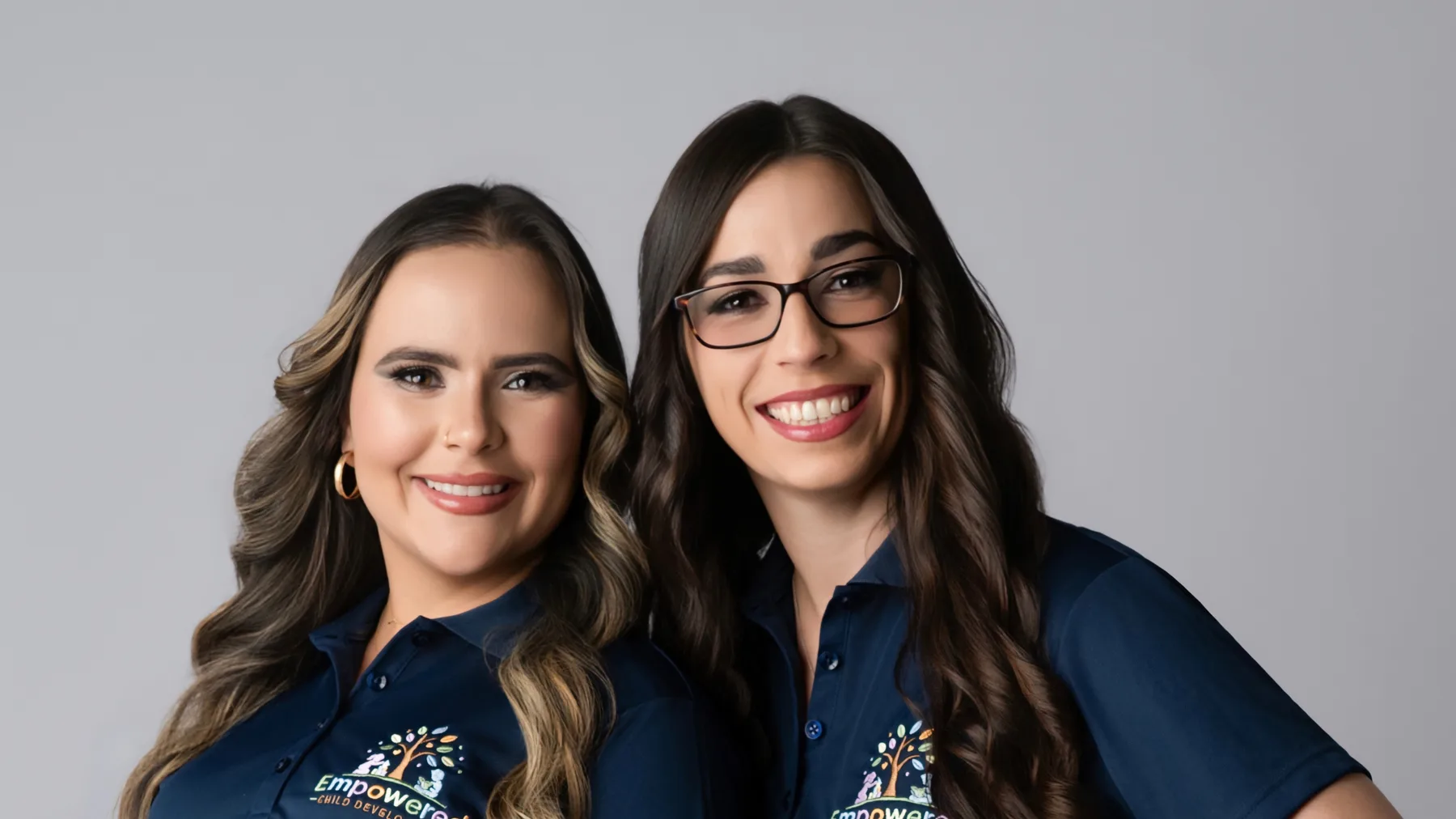 Laury Montes de Oca and Liz Keyes standing together in Empowered Child Development polo shirts.